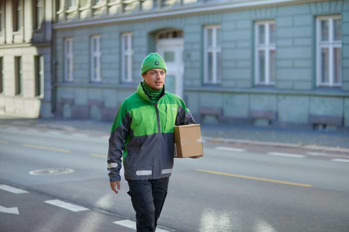 Bringbud går med paket i stadsmiljö