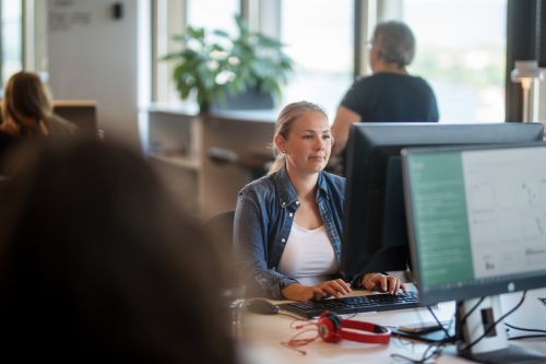 En kvinna sitter framför en dataskärm