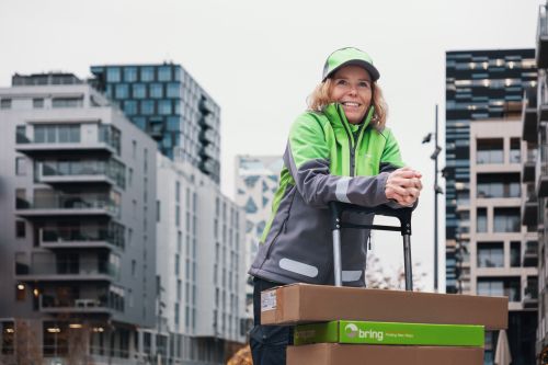 En leednde Bringbud står lutad över en pirra med paket på i stadsmiljö
