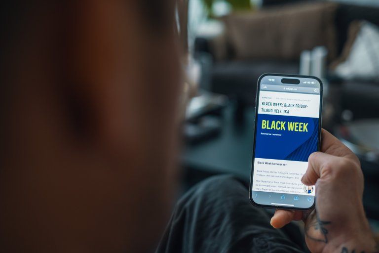 En person sitter med en mobil i handen med en webbutik som visar att det är Black Week