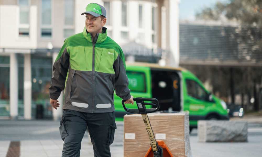 A Bring driver pulls a pallet jack with parcels