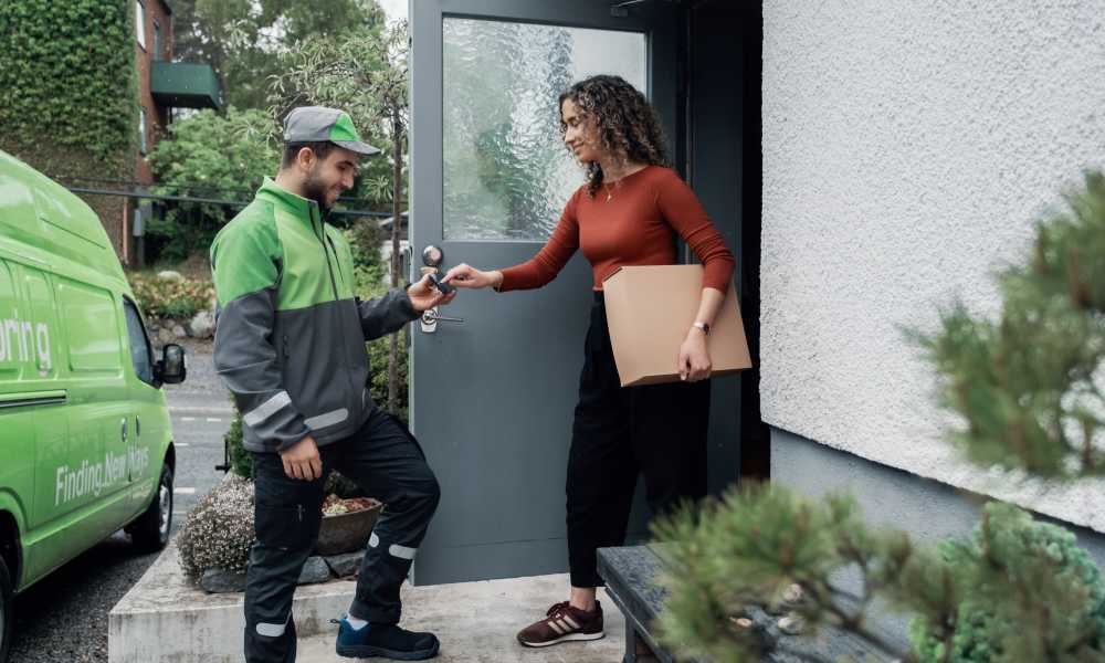 A woman is signing for a parcel that has been delivered by a Bring driver