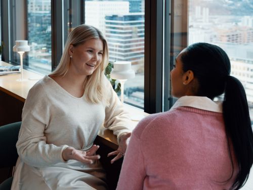 2 kvinnor pratar tillsammans på ett kontor