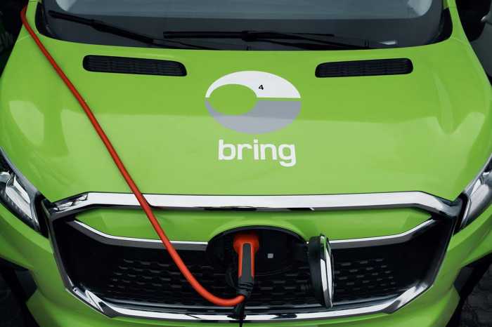 En närbild på en motorhuv på en elektrisk Bringbil som laddas