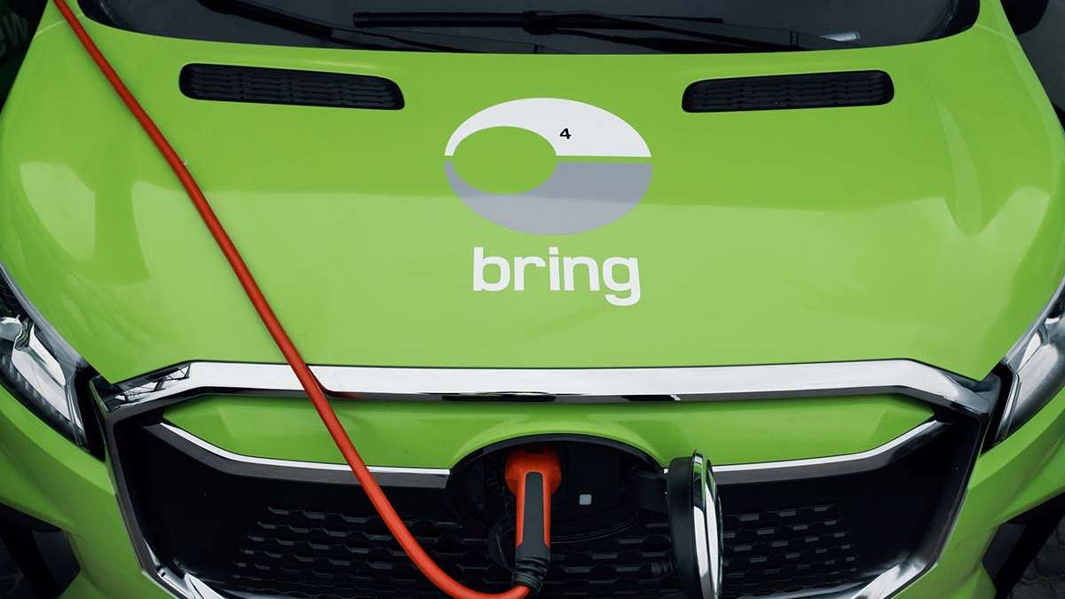 En närbild på en motorhuv på en elektrisk Bringbil som laddas