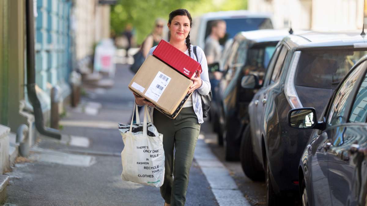 Kvinna bär på paket.