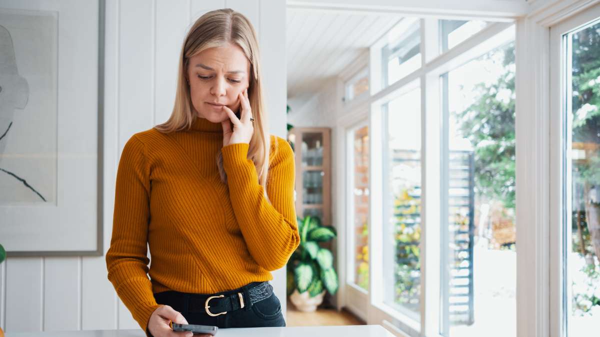 Bekymrad kvinna med mobiltelefon