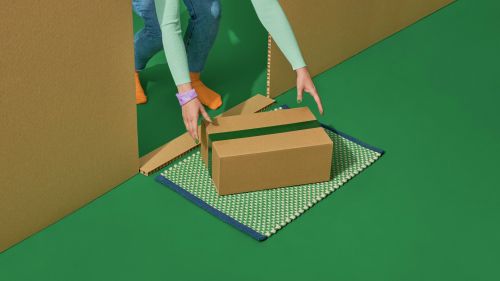 En person har fått en Bring hemleverans och tar emot ett paket vid sin dörr