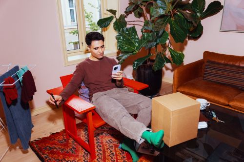 En kille ska skriva sin Bring-kod på ett paket